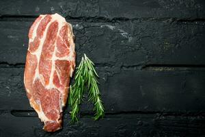 Raw steak of pork with rosemary. photo