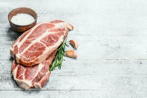 Raw pork steaks with salt. photo