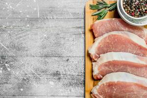 Raw pork steaks with spices and herbs. photo