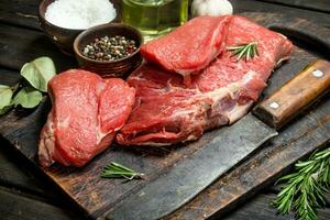 Raw meat. Fresh beef with spices and an old knife. photo