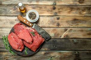 Raw meat. Fresh beef on a cutting Board with herbs and spices. photo