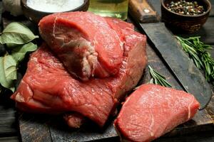 Raw meat. Fresh beef with spices and an old knife. photo