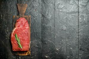 Raw meat. A piece of fresh beef with rosemary. photo