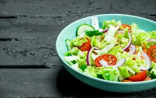 Fresh vegetable salad of tomatoes, cucumbers and red onions. photo