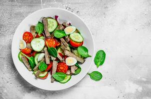 Healthy salad. Salad with boiled beef, vegetables and quail eggs. photo