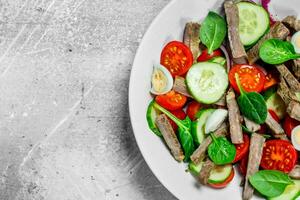 Healthy salad. Salad with boiled beef, vegetables and quail eggs. photo