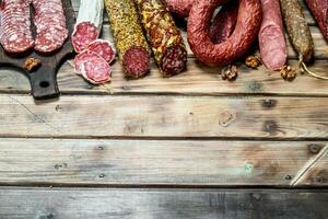 Various types of salami on a Board with nuts. photo