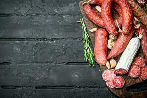 Different types of salami with spices and herbs. photo