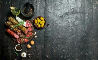 Variety of smoked salami with olives, herbs and spices. photo