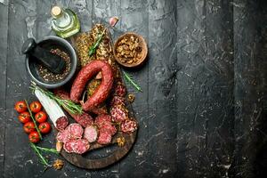 Different types of smoked salami with aromatic seasonings. photo