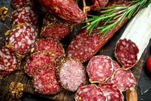 Different types of smoked salami with aromatic seasonings. photo