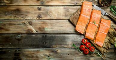 Raw salmon fish filet with tomatoes and spices. photo