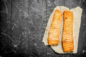 Grilled salmon fillet on paper . photo