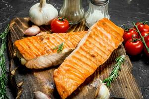 Steaks grilled salmon with spices and tomatoes. photo