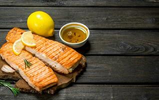 Steaks grilled salmon with lemon wedges. photo