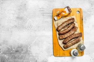 Grill beef sausages on a wooden Board . photo