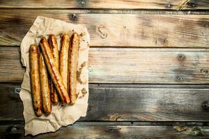 Grilled sausage of pork and beef on paper. photo