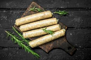 Raw sausages with seasonings and herbs. photo