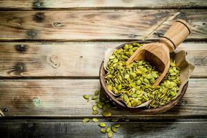 Pumpkin seeds in bowl with scoop. photo