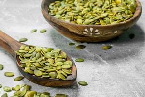 Pumpkin seeds in a wooden spoon. photo