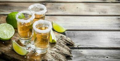 Tequila in a shot glass of salt on the cutting Board. photo