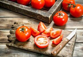 Cut tomatoes on a cutting Board with a knife. photo