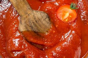Tomato sauce with a wooden scoop. photo