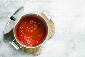 tomate salsa en un maceta en papel. foto
