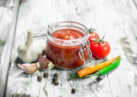 Tomato sauce in a jar and spices. photo