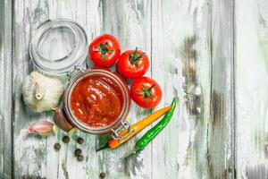 Tomato sauce in a jar and spices. photo