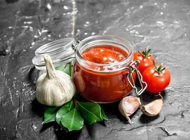 Tomato sauce in bowl with garlic and Bay leaf. photo