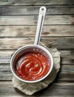 Tomato sauce in a saucepan on paper. photo