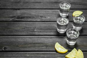 Vodka in a shot glass and lemon slices. photo