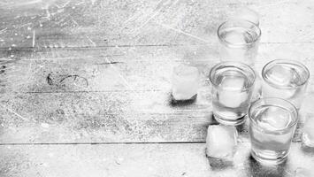 Vodka in a shot glass and ice cubes. photo