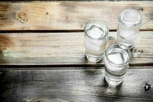 vodka en un Disparo vaso y hielo cubitos. foto