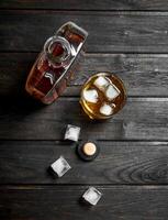 Whiskey in a bottle with ice cubes. photo