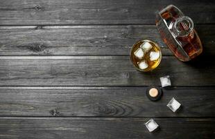 Whiskey in a bottle with ice cubes. photo