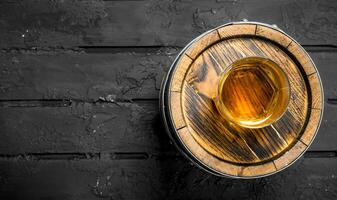Whiskey in a glass on a barrel. photo