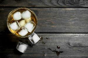 Whiskey in a glass with ice cubes. photo