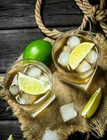 Whiskey in a glass with lime and ice on the sack. photo