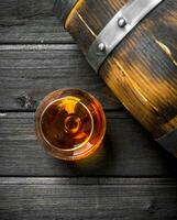 Cognac in a glass with a barrel. photo