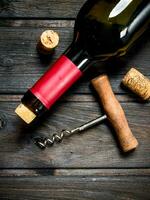 bottle of red wine with a corkscrew. photo