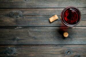 vino antecedentes. un vaso de rojo vino con corchos foto