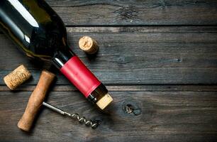 bottle of red wine with a corkscrew. photo