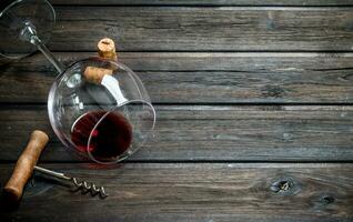 Red wine in a wine glass with a corkscrew. photo