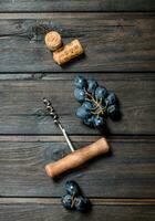 Wine background. Grapes with corkscrew and corks. photo