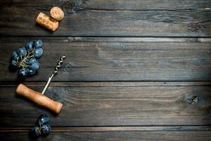 Wine background. Grapes with corkscrew and corks. photo