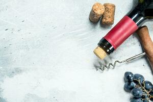 Wine background. Red wine with a grapes and a corkscrew. photo