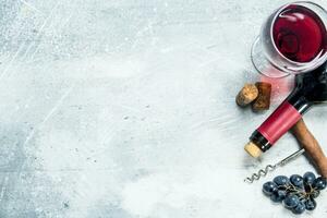 Wine background. Red wine with a grapes and a corkscrew. photo