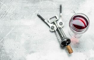 Wine background. Red wine with corkscrew. photo
